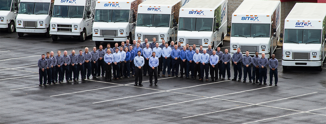 group of employees in front of trucks